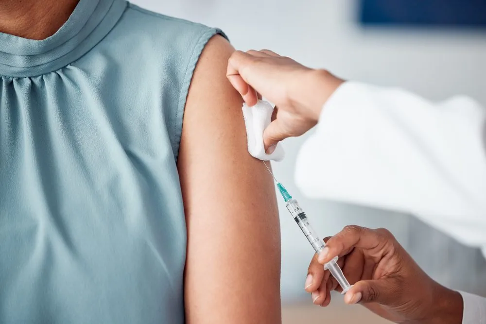 Pharmacist giving a vaccination into a patient’s upper arm