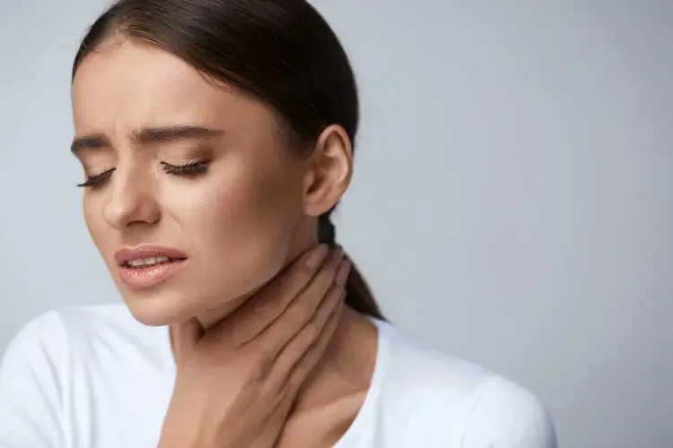 Woman holding her throat with a painful sore throat